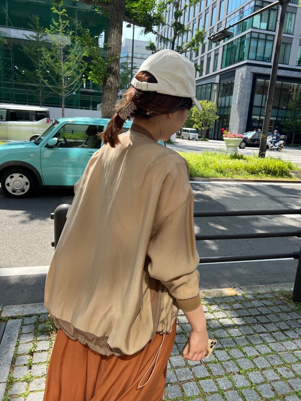 ベージュ系のブルゾン、ブラウン系のワンピース、ホワイト系のTシャツ/カットソーを着用したレディースの夏コーディネートの3枚目の写真