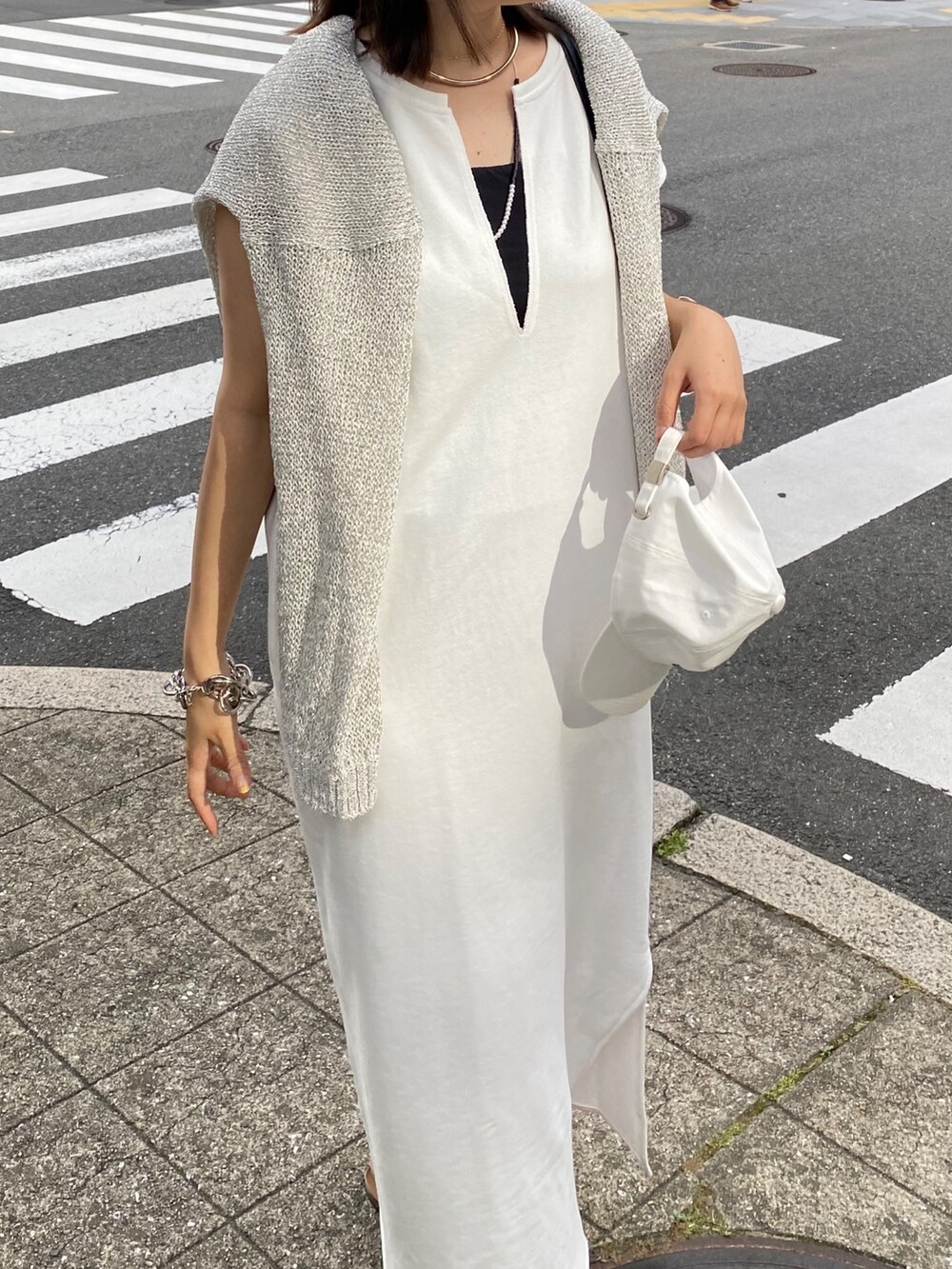 ホワイト系のワンピース、ホワイト系のキャップ、ホワイト系のネックレスを着用したレディースの夏コーディネートの7枚目の写真