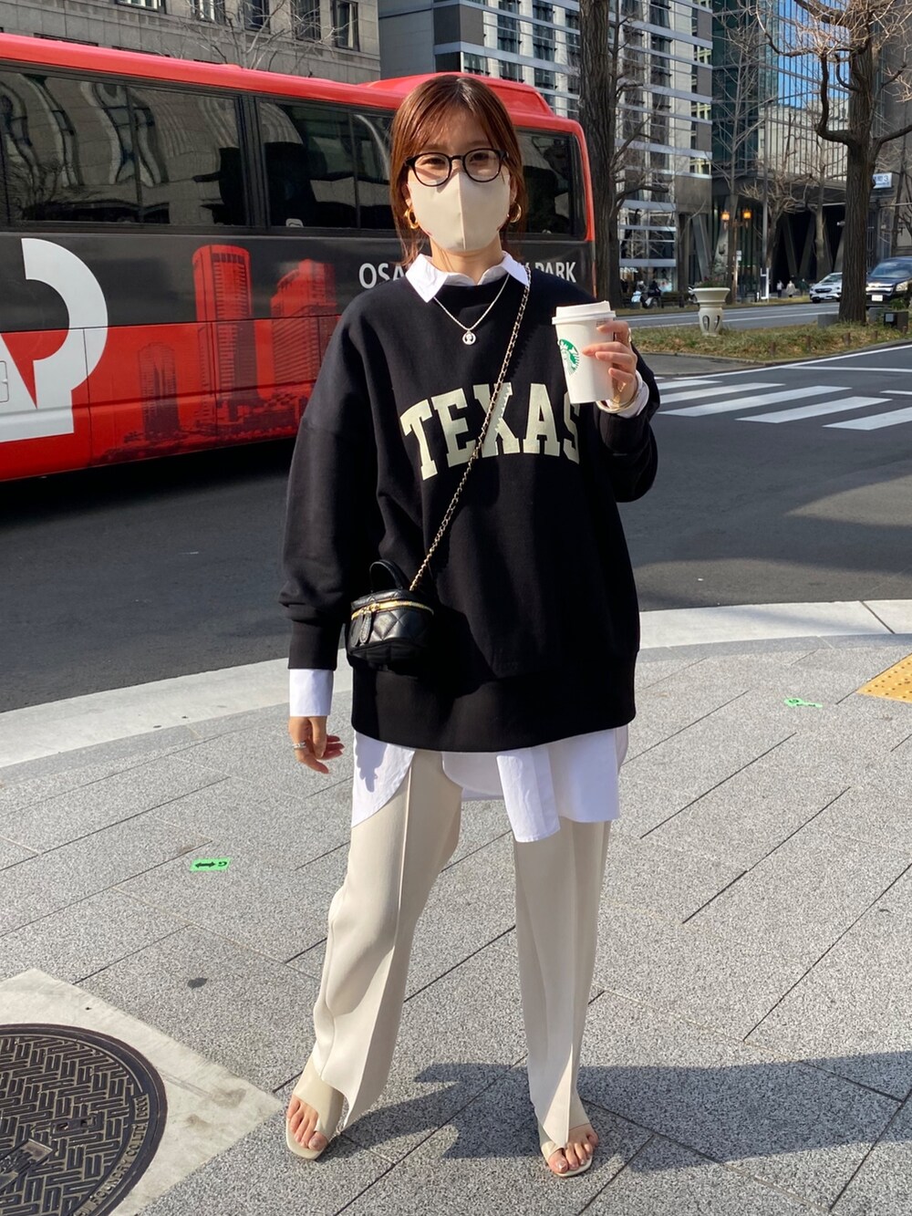 ブラック系のスウェット、ホワイト系のシャツ/ブラウス、ホワイト系のスラックスを着用したレディースの春コーディネートの3枚目の写真