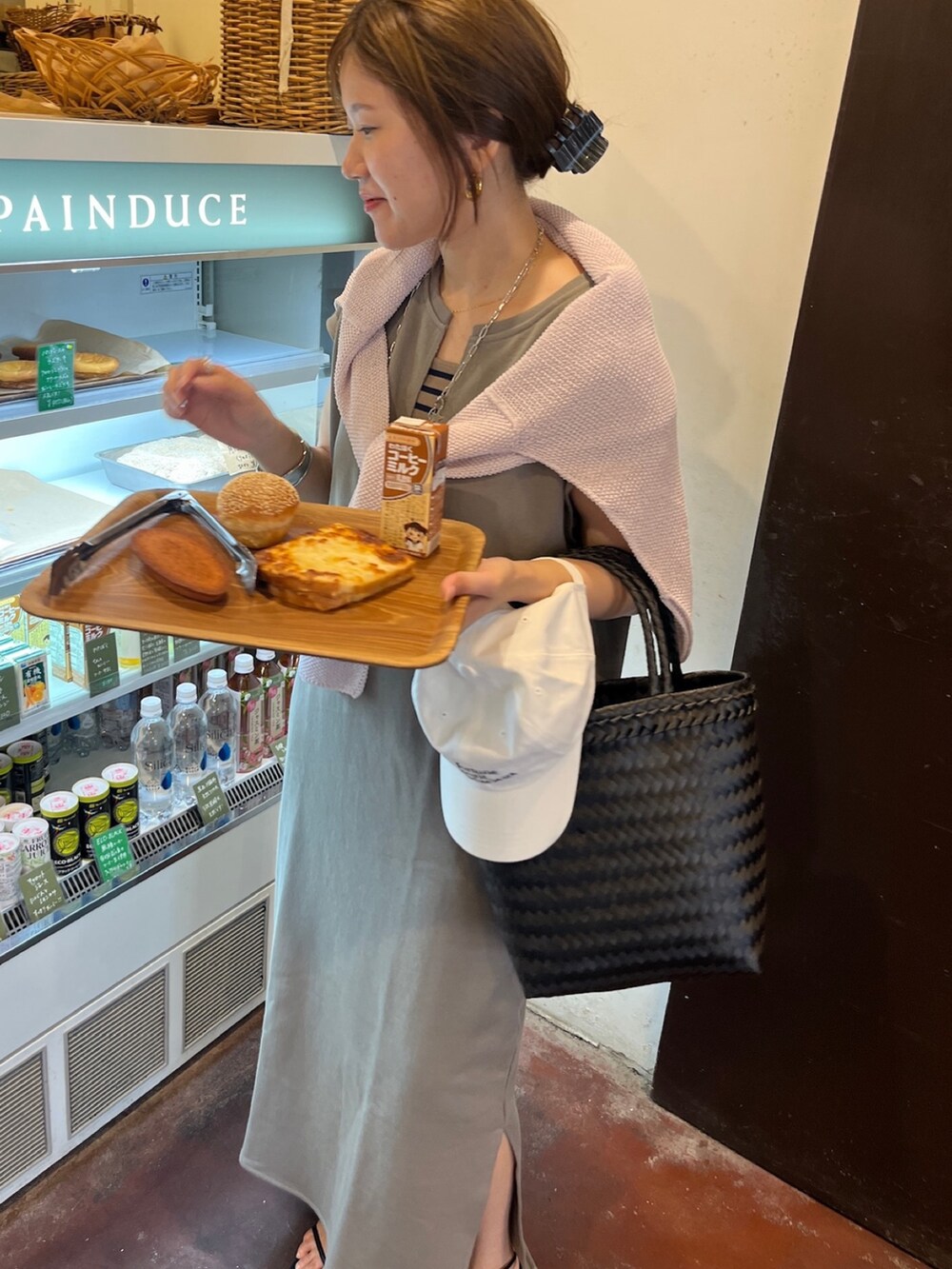 ホワイト系のワンピース、ブラック系のかごバッグ、ブラック系のニット/セーターを着用したレディースの春コーディネートの5枚目の写真