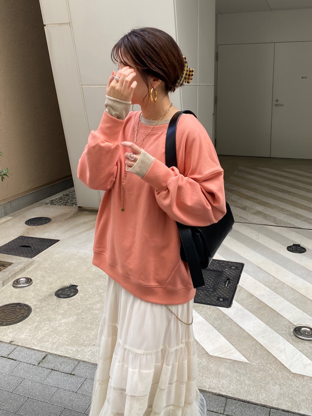 ブラウン系のその他アウター、オレンジ系のスウェット、ホワイト系のスカートを着用したレディースの冬コーディネートの3枚目の写真