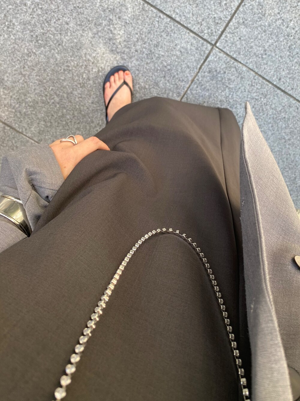 グレー系のワンピース、グレー系のテーラードジャケット、シルバー系のネックレスを着用したレディースの秋コーディネートの4枚目の写真