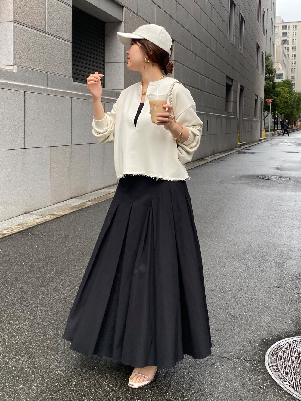 ベージュ系のスウェット、ブラック系のスカート、ホワイト系のショルダーバッグを着用したレディースの冬コーディネートの9枚目の写真