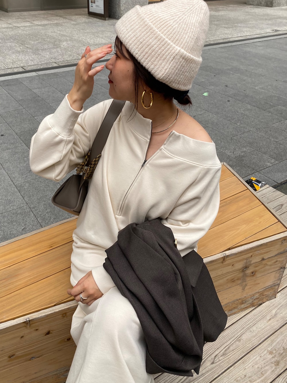 ベージュ系のワンピース、グレー系のテーラードジャケット、グレー系のショルダーバッグを着用したレディースの冬コーディネートの7枚目の写真