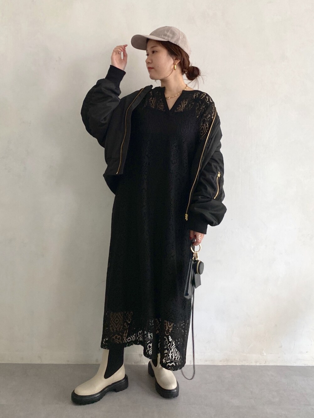 ブラック系のMA-1、ブラック系のワンピース、ホワイト系のブーツを着用したレディースの秋コーディネートの2枚目の写真