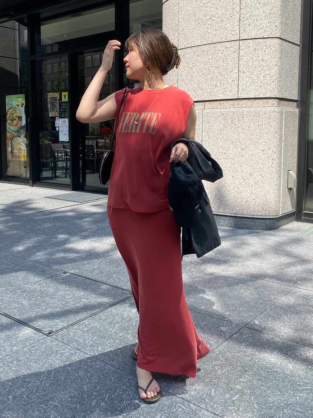 グレー系のテーラードジャケット、レッド系のTシャツ/カットソー、ブラック系のショルダーバッグを着用したレディースの春コーディネートの6枚目の写真