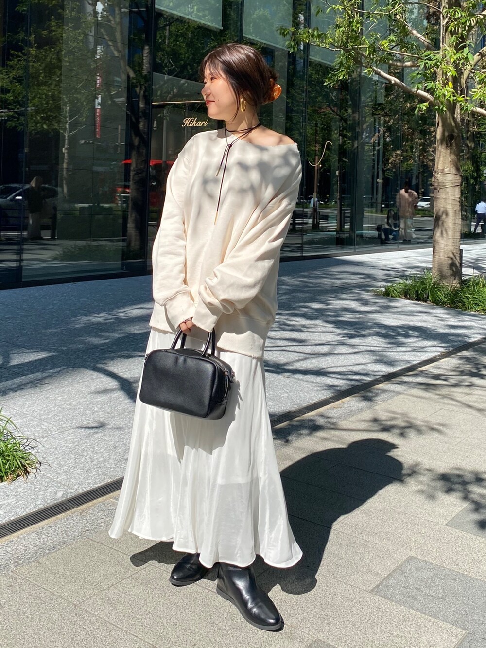 ホワイト系のTシャツ/カットソー、ホワイト系のスカート、ブラウン系のショルダーバッグを着用したレディースの冬コーディネートの2枚目の写真