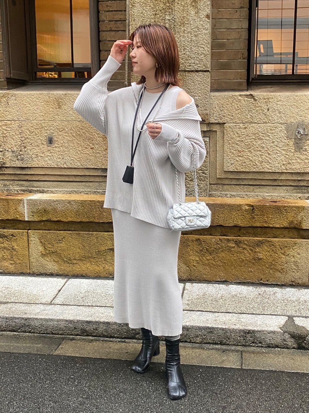 ホワイト系のブルゾン、グレー系のワンピース、シルバー系のショルダーバッグを着用したレディースの春コーディネートの9枚目の写真