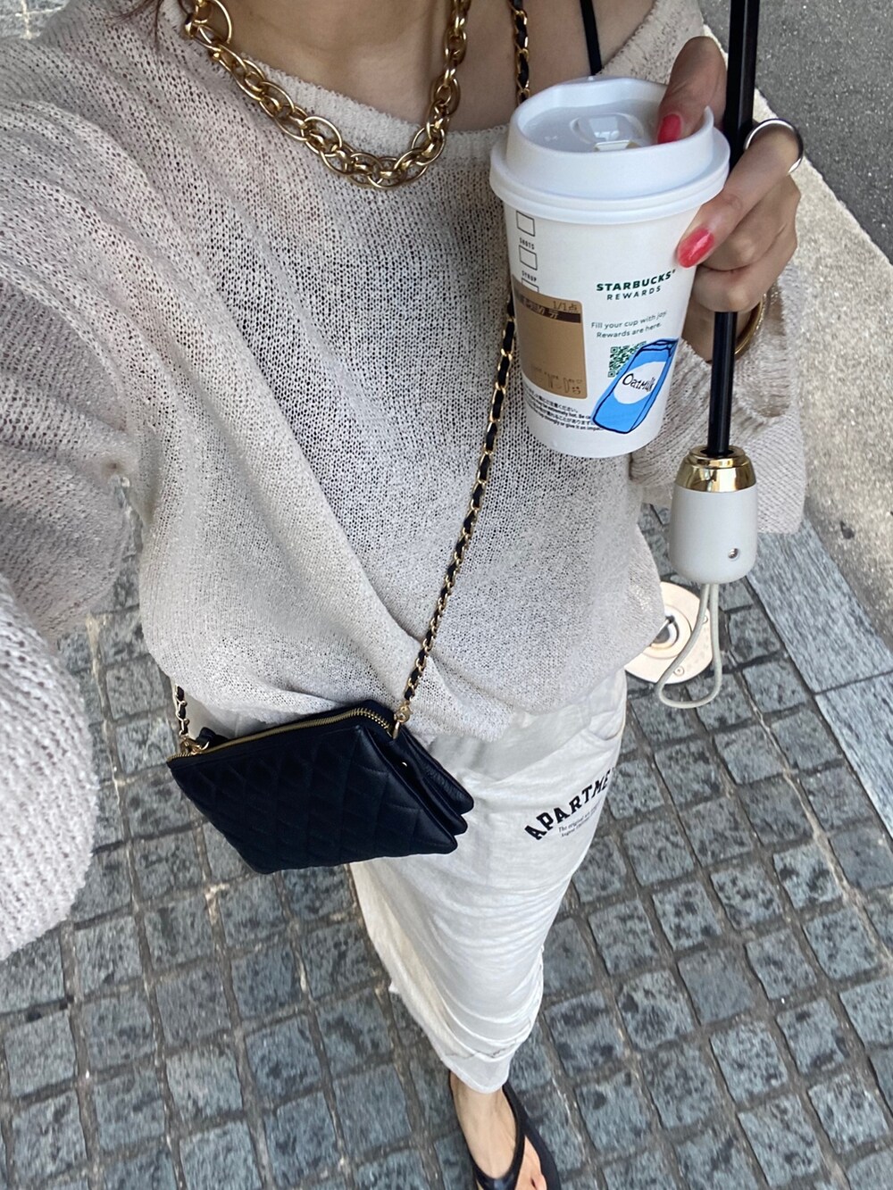 ベージュ系のニット/セーター、ベージュ系のスカート、ブラック系のショルダーバッグを着用したレディースの夏コーディネートの10枚目の写真