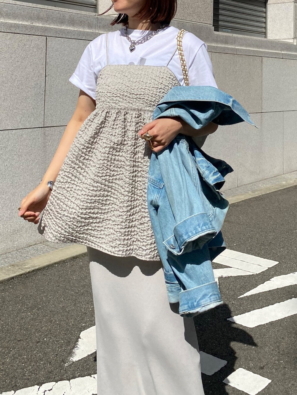 グレー系のキャミソール、ベージュ系のスカート、ブルー系のジャケット/アウターを着用したレディースの春コーディネートの8枚目の写真