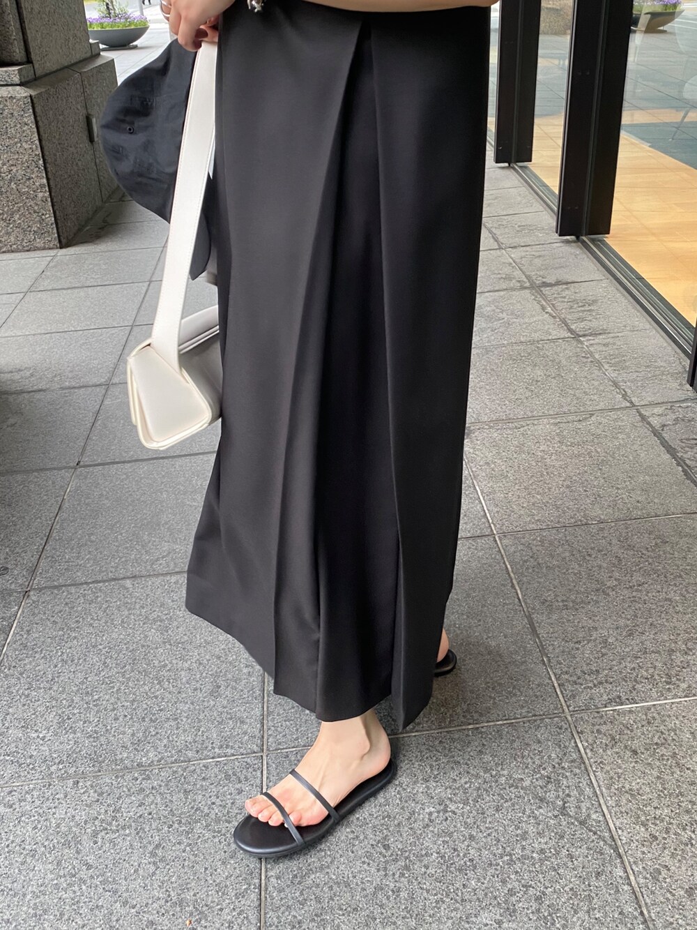 ホワイト系のテーラードジャケット、ブラック系のワンピースを着用したレディースの夏コーディネートの3枚目の写真