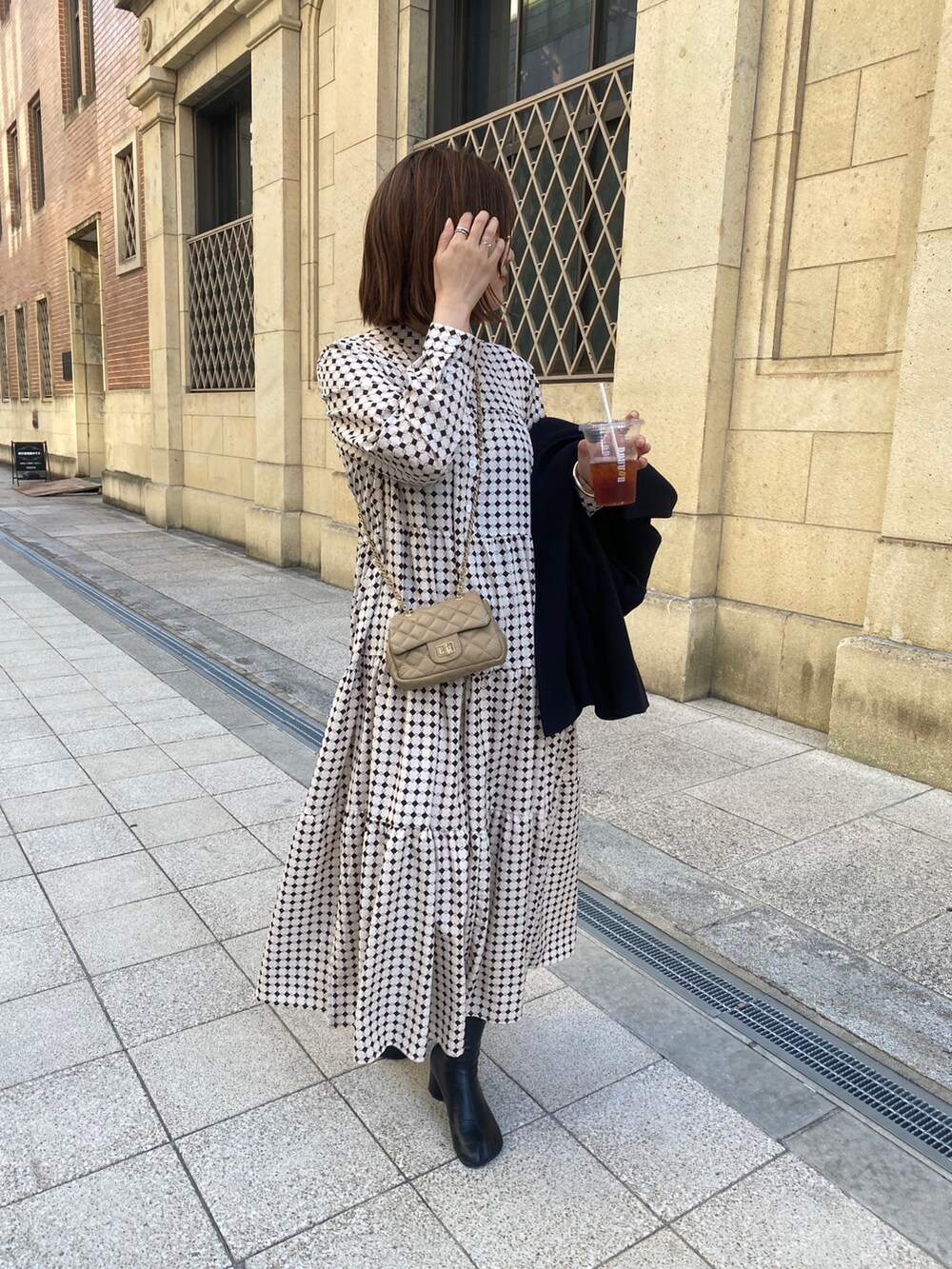 ベージュ系のワンピース、ブラック系のその他シューズ、ベージュ系のショルダーバッグを着用したレディースの冬コーディネートの4枚目の写真