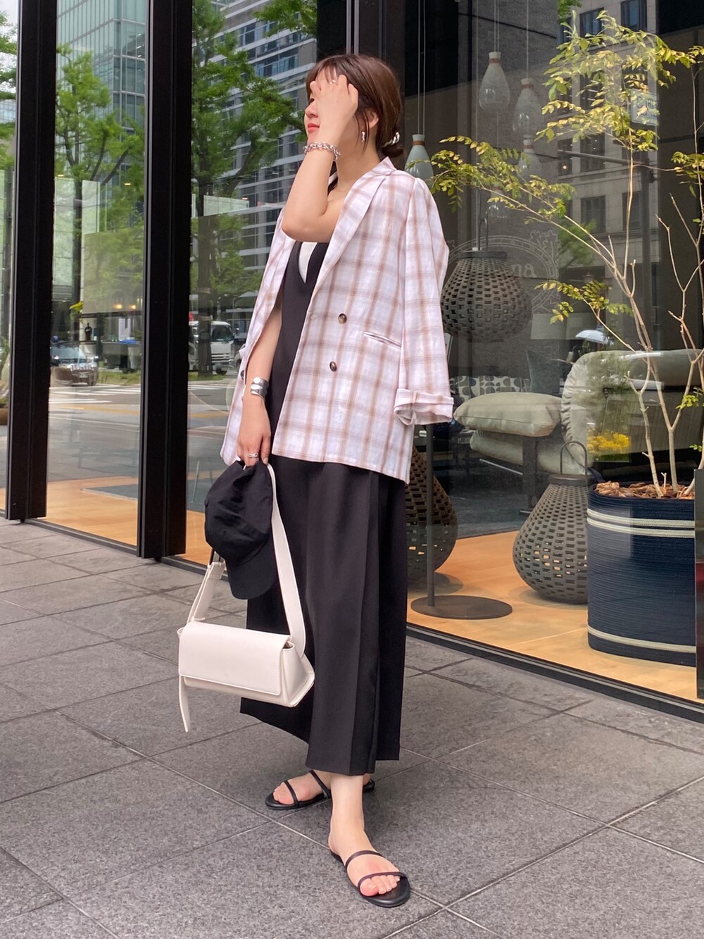ホワイト系のテーラードジャケット、ブラック系のワンピースを着用したレディースの夏コーディネートの2枚目の写真