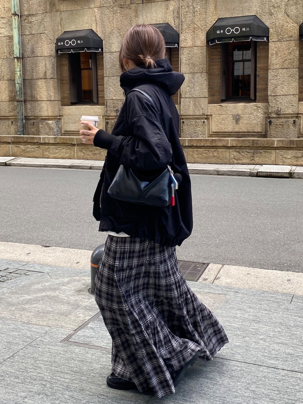 ブラック系のその他アウター、ホワイト系のTシャツ/カットソー、ブラック系のスカートを着用したレディースの春コーディネートの2枚目の写真