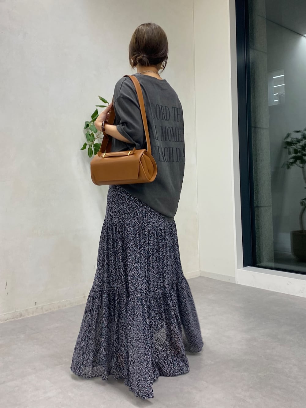 グレー系のTシャツ/カットソー、ピンク系のスカート、ブラウン系のショルダーバッグを着用したレディースの夏コーディネートの2枚目の写真