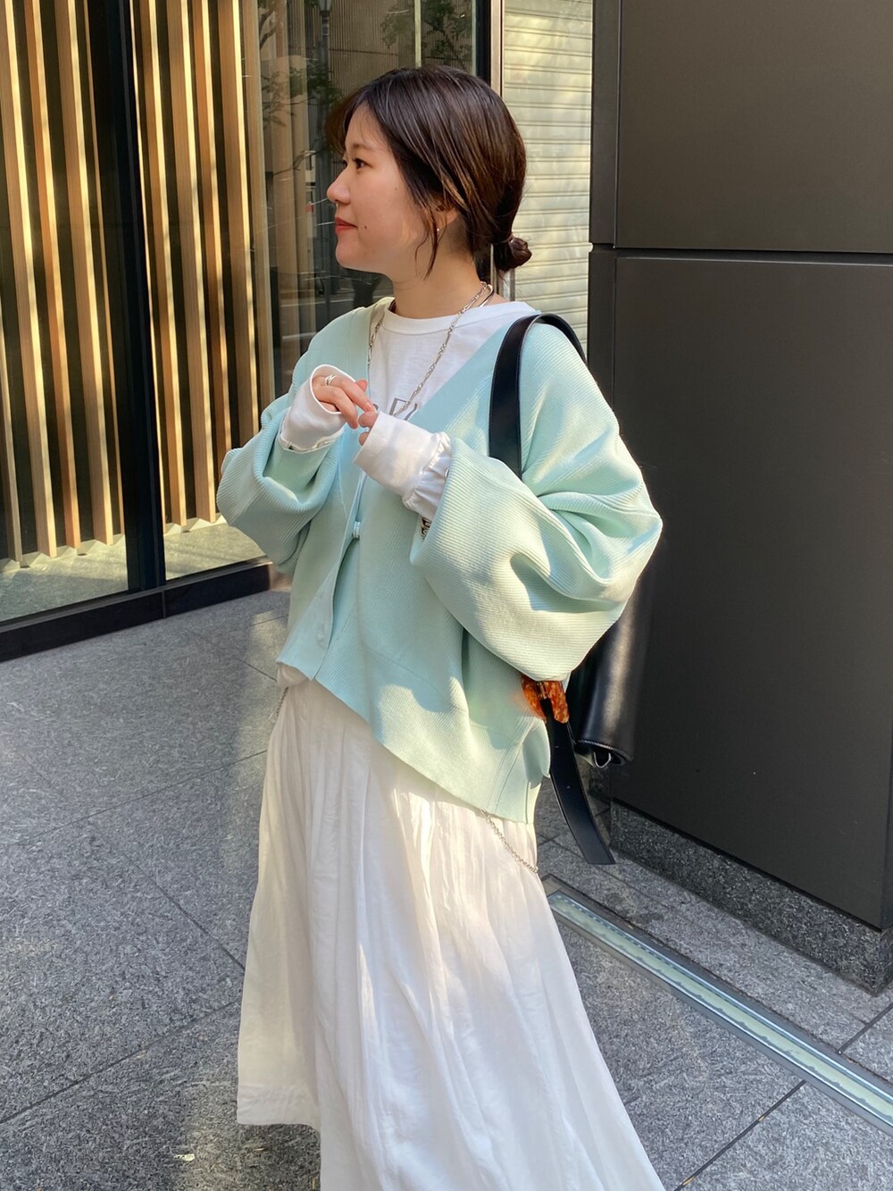 グリーン系のカーディガン/ボレロ、ホワイト系のスカートを着用したレディースの冬コーディネートの8枚目の写真