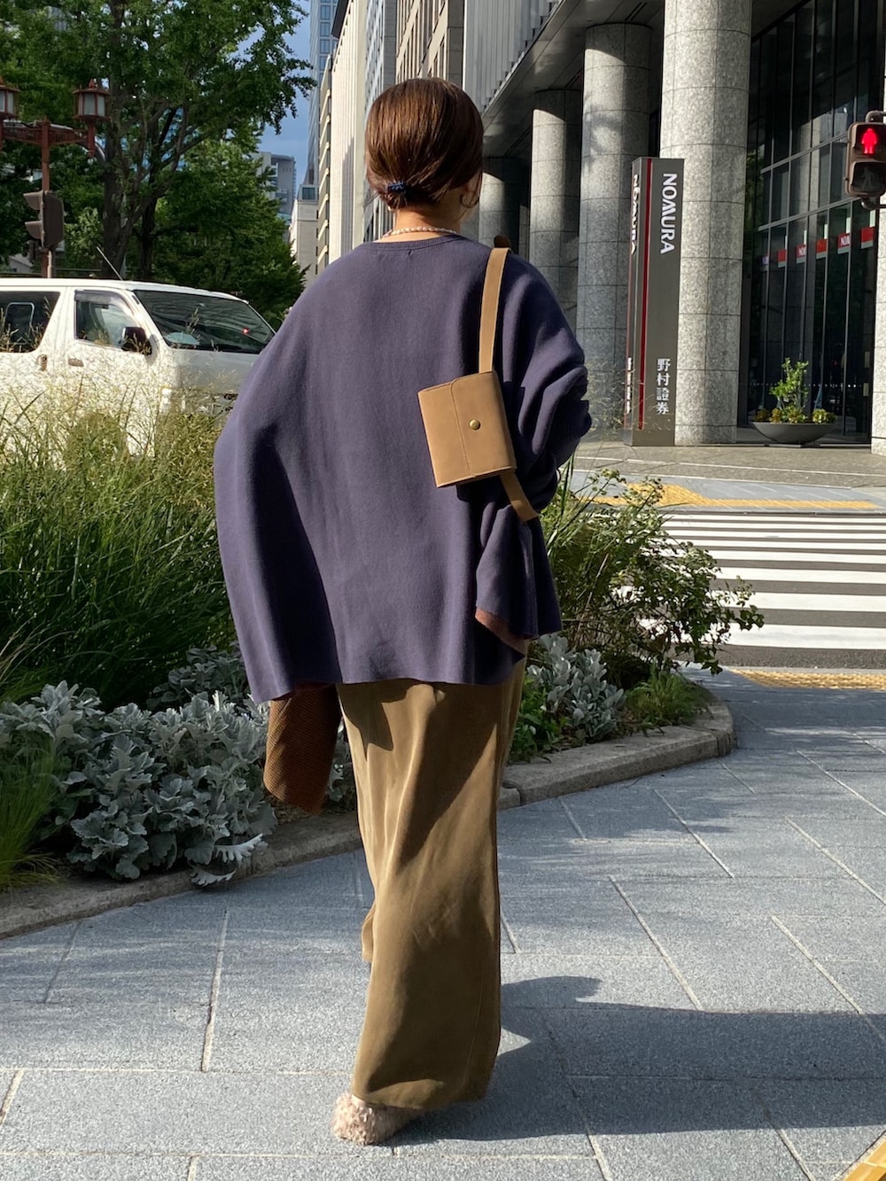 ブルー系のニット/セーター、グリーン系のスカート、ブラウン系のテーラードジャケットを着用したレディースの秋コーディネートの9枚目の写真