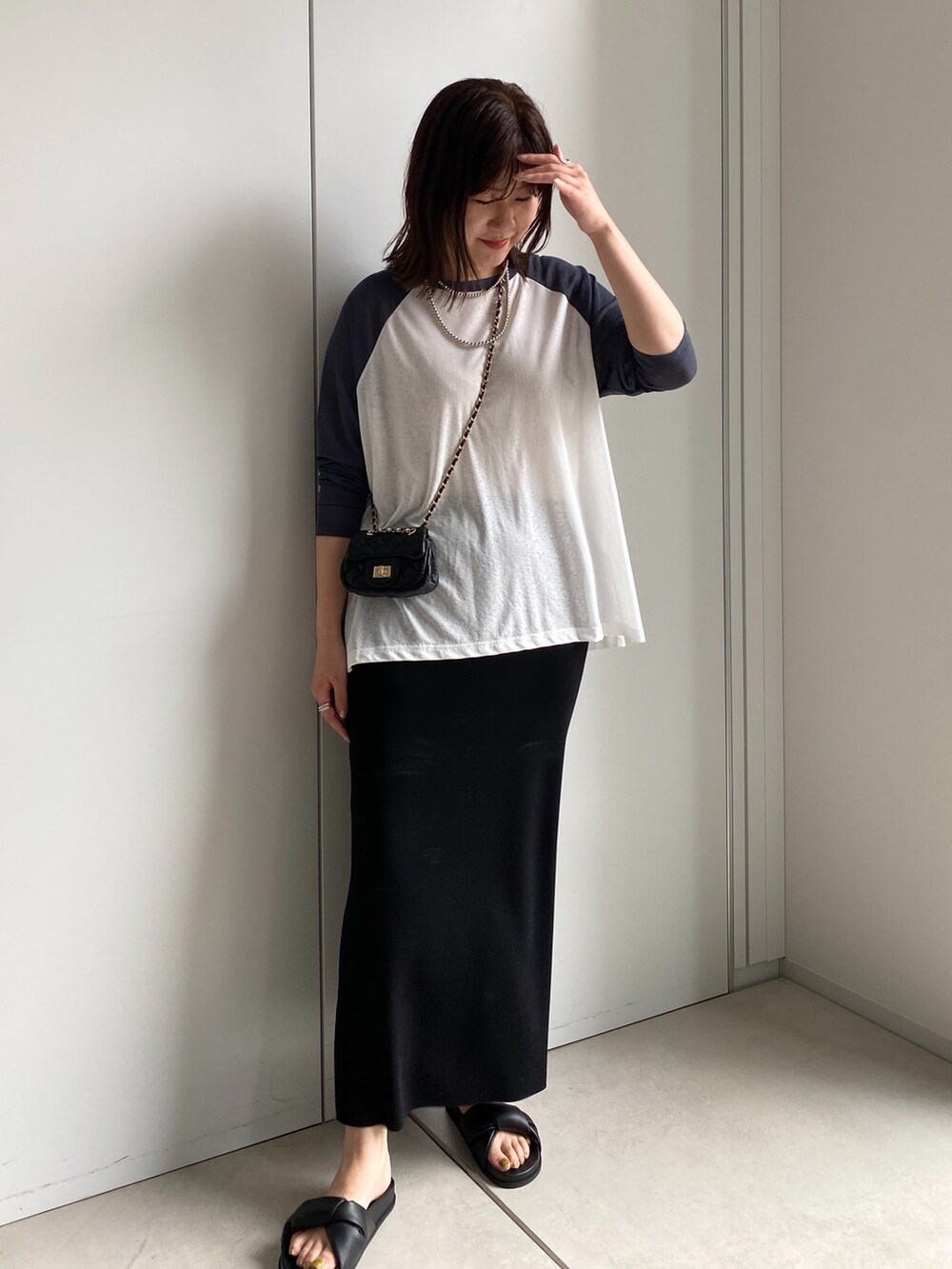 ホワイト系のTシャツ/カットソー、ブラック系のスカート、ブラック系のショルダーバッグを着用したレディースの夏コーディネートの4枚目の写真