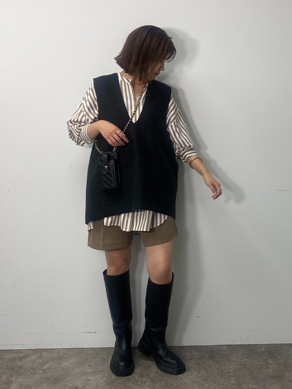 グレー系のベスト、ベージュ系のシャツ/ブラウス、イエロー系のその他パンツを着用したレディースの秋コーディネートの5枚目の写真