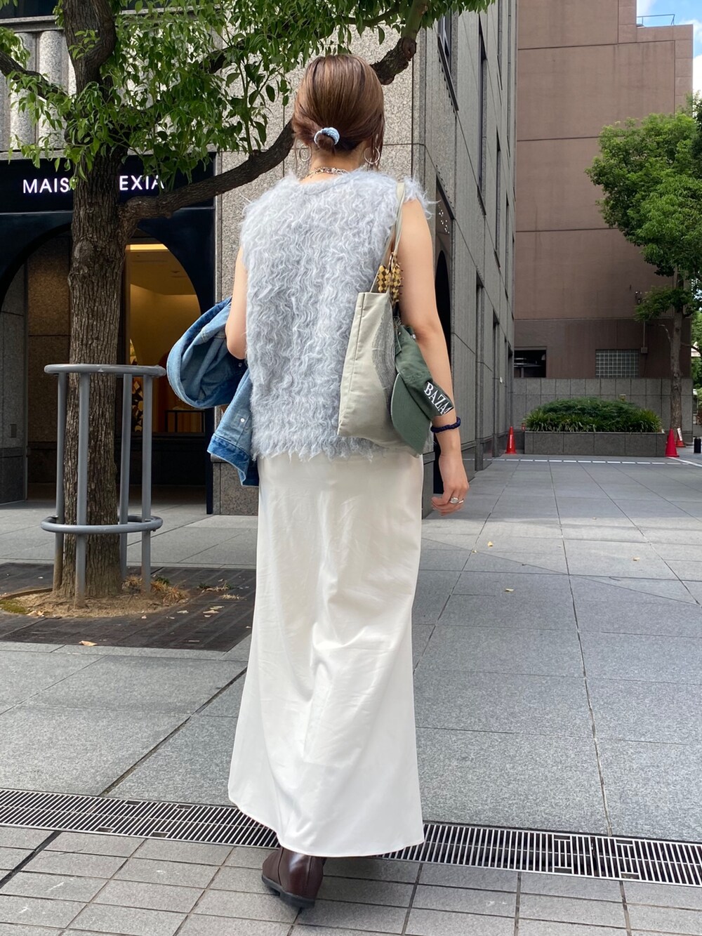 グレー系のニット/セーター、ブルー系のその他アウター、ホワイト系のスカートを着用したレディースの秋コーディネートの5枚目の写真