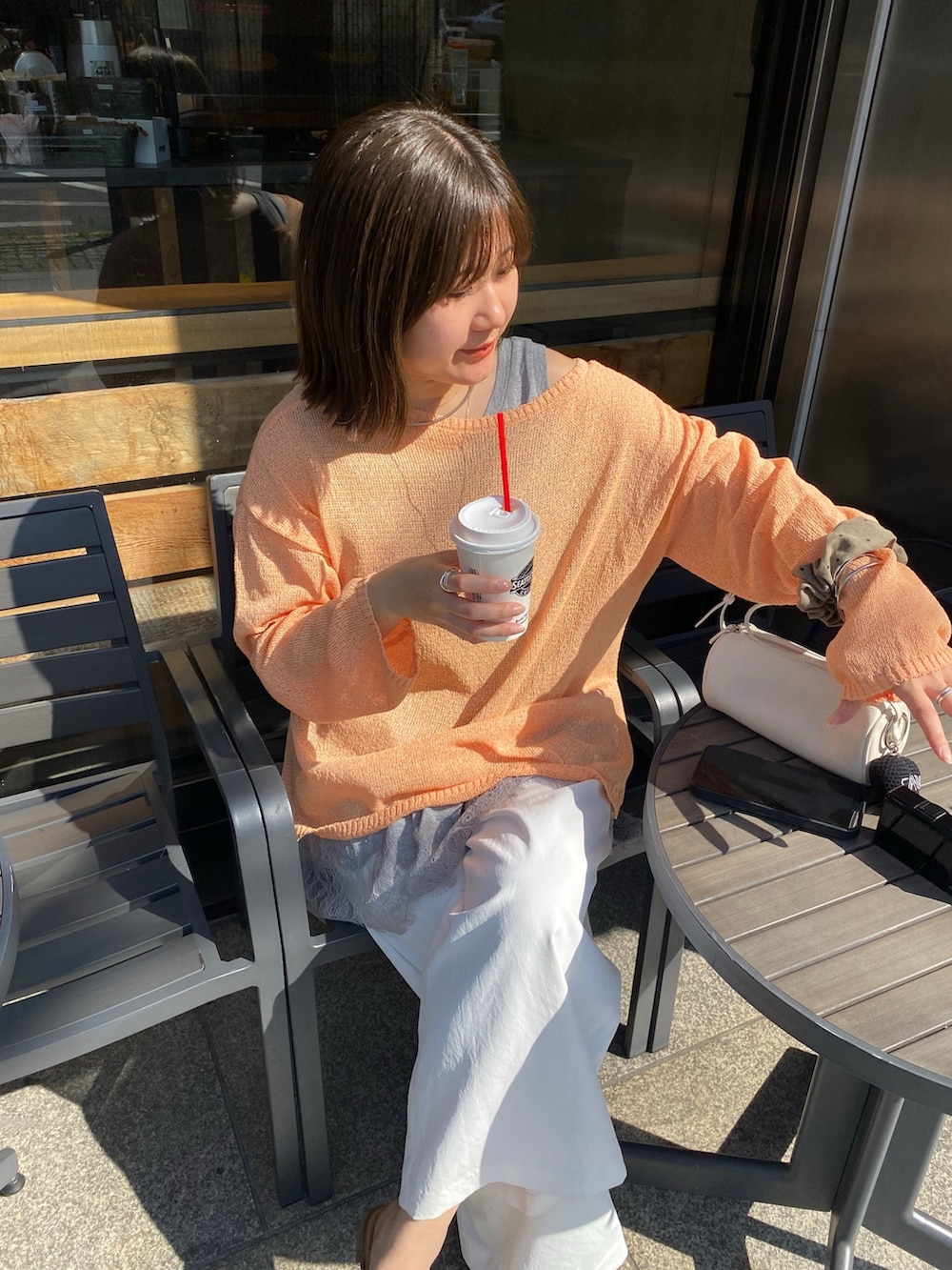 オレンジ系のニット/セーター、グレー系のTシャツ/カットソー、ホワイト系のその他パンツを着用したレディースの春コーディネートの10枚目の写真