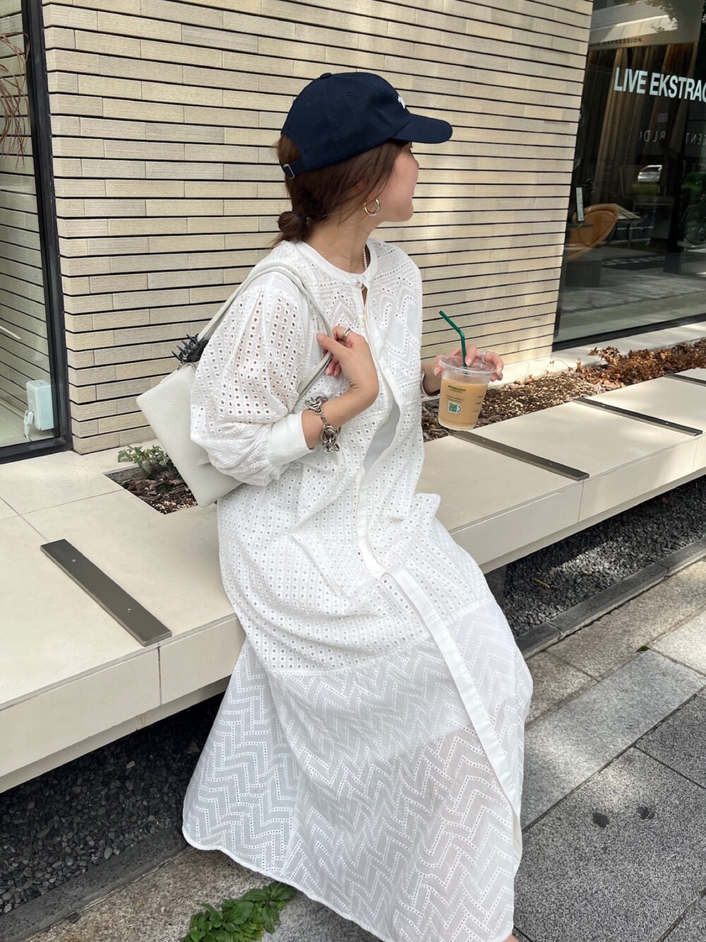 ホワイト系のワンピース、ホワイト系のショルダーバッグ、ゴールド系のブレスレットを着用したレディースの夏コーディネートの9枚目の写真