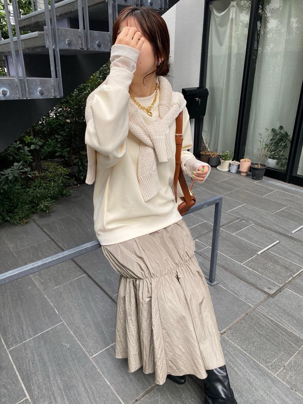 ホワイト系のワンピース、ブラック系のブーツ、シルバー系のネックレスを着用したレディースの冬コーディネートの2枚目の写真