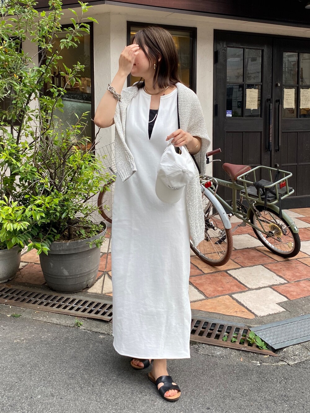 ホワイト系のワンピース、ホワイト系のキャップ、ホワイト系のネックレスを着用したレディースの夏コーディネートの9枚目の写真