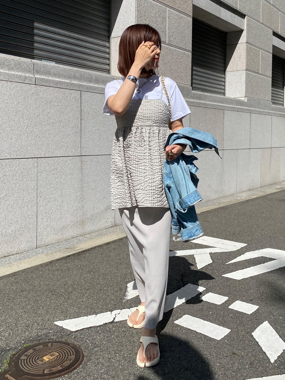 グレー系のキャミソール、ベージュ系のスカート、ブルー系のジャケット/アウターを着用したレディースの春コーディネートの9枚目の写真