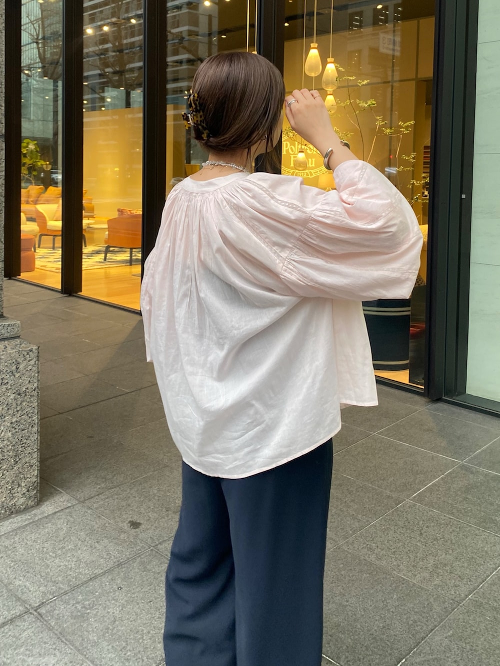 ピンク系のシャツ/ブラウス、ブルー系のスラックス、その他のネックレスを着用したレディースの春コーディネートの5枚目の写真