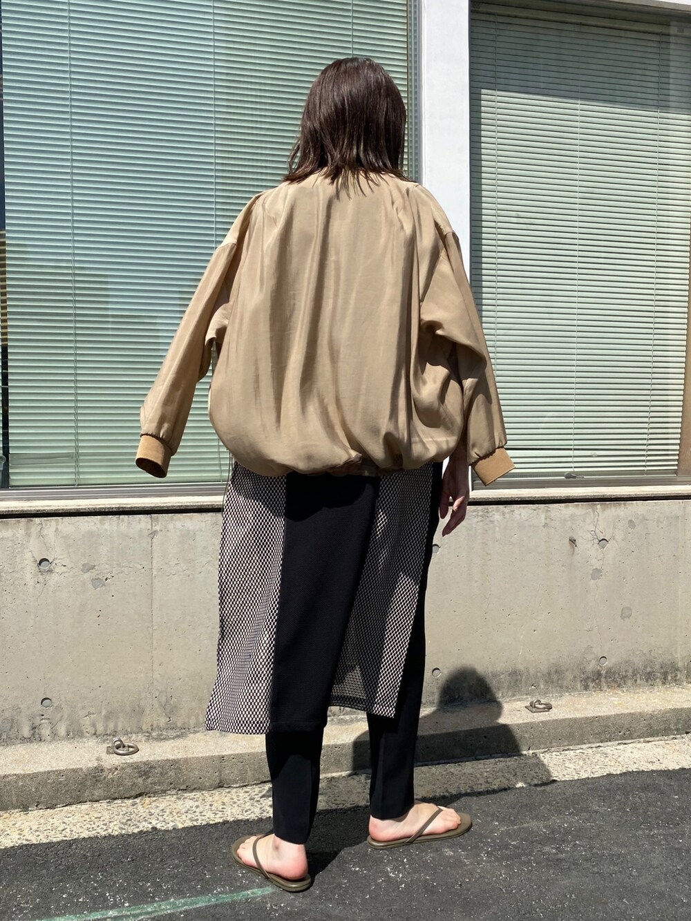 ベージュ系のブルゾン、ブラック系のワンピースを着用したレディースの夏コーディネートの4枚目の写真