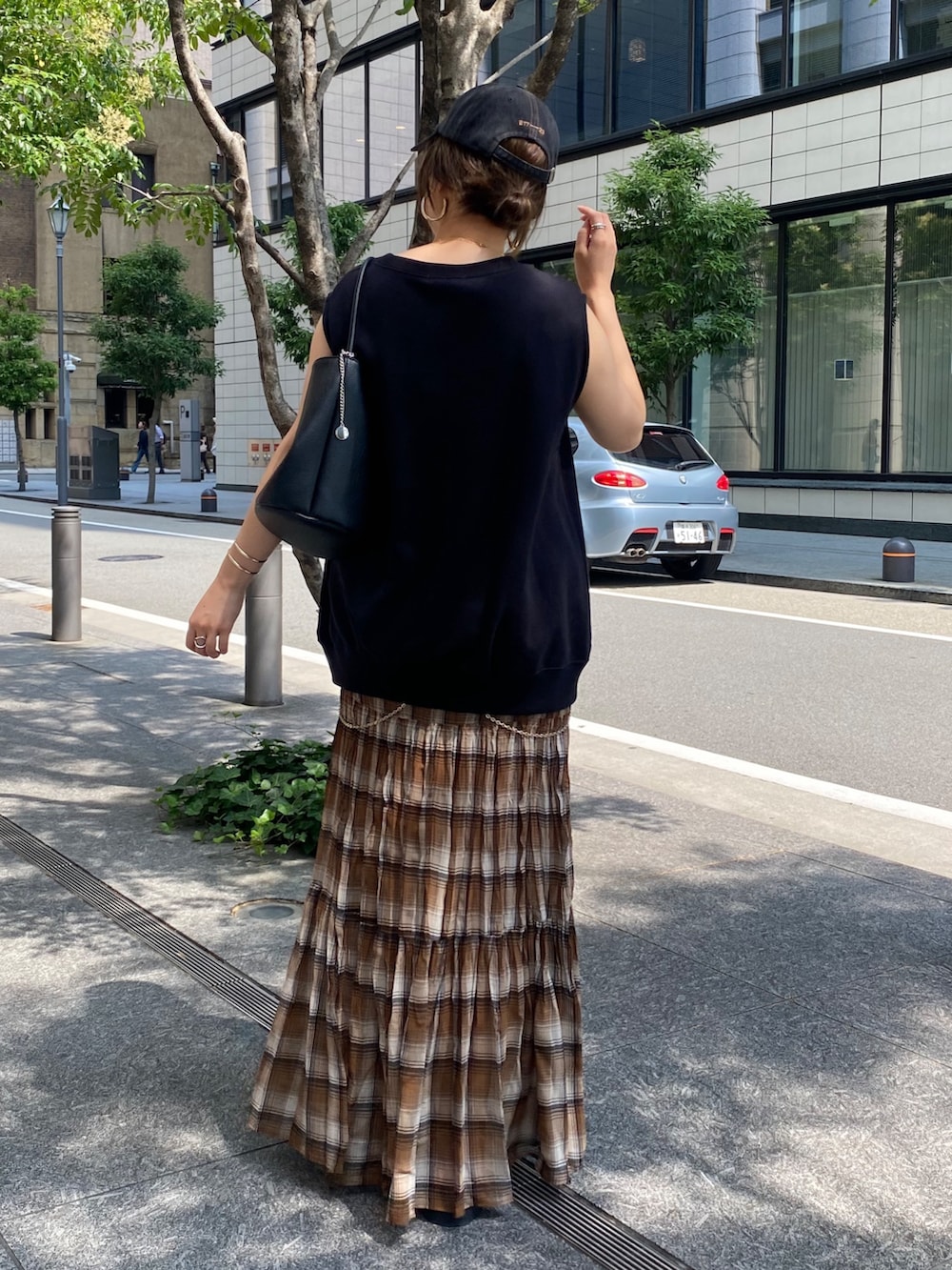 ブラック系のTシャツ/カットソー、ブラウン系のスカート、ブラック系のショルダーバッグを着用したレディースの夏コーディネートの4枚目の写真