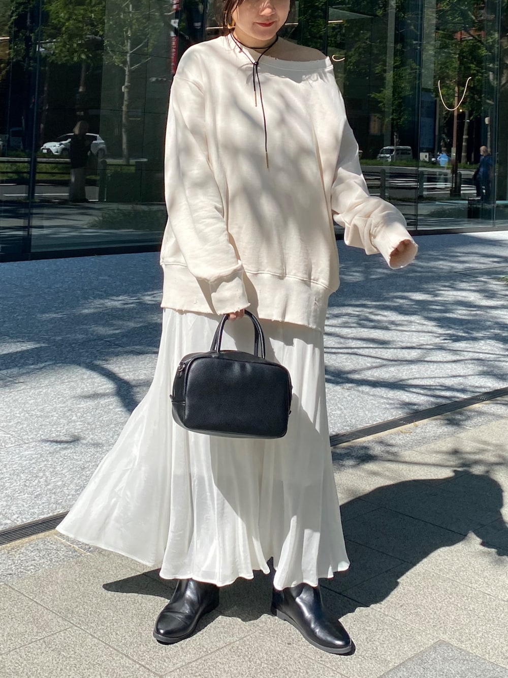 ホワイト系のTシャツ/カットソー、ホワイト系のスカート、ブラウン系のショルダーバッグを着用したレディースの冬コーディネートの4枚目の写真