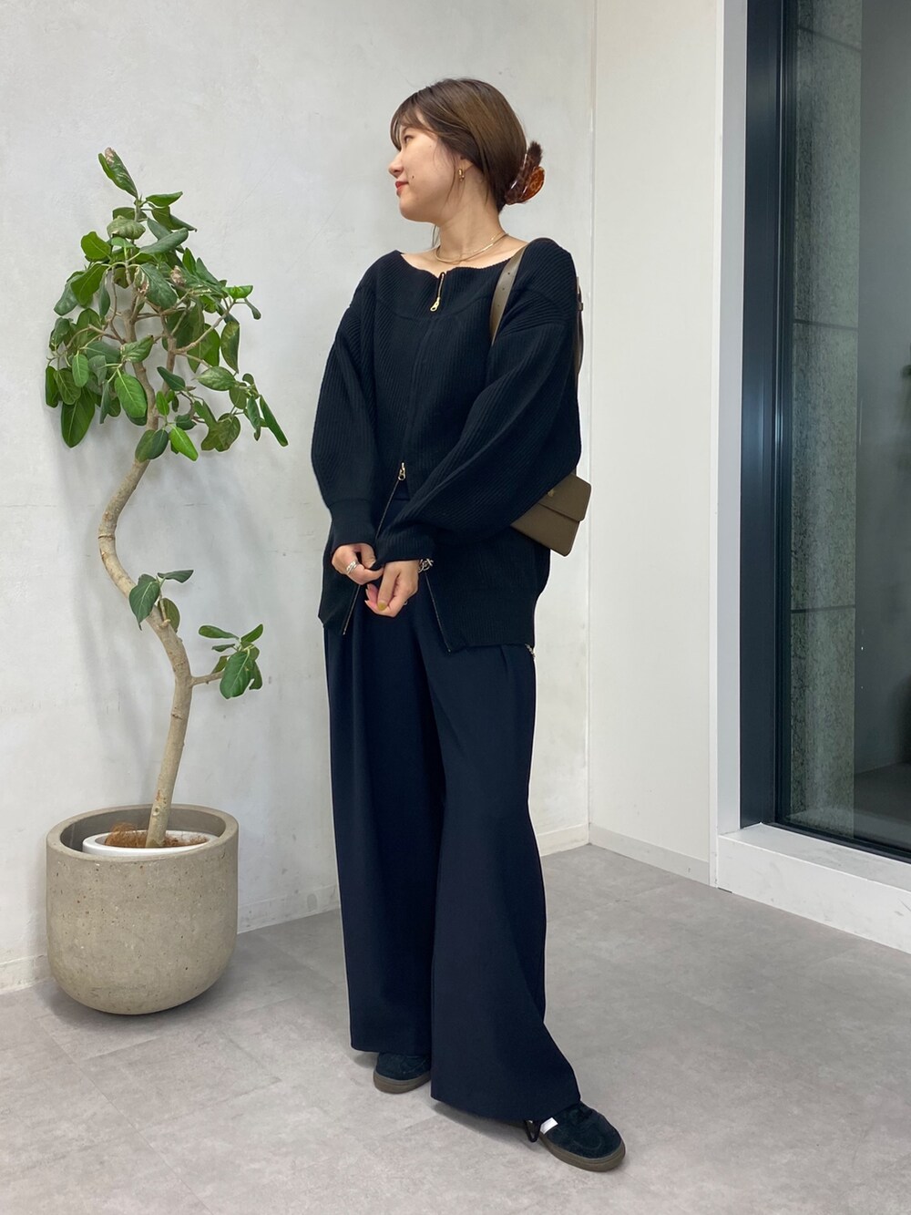 ブラック系のニット/セーター、ブルー系のスラックス、ゴールド系のサスペンダーを着用したレディースの秋コーディネートの5枚目の写真