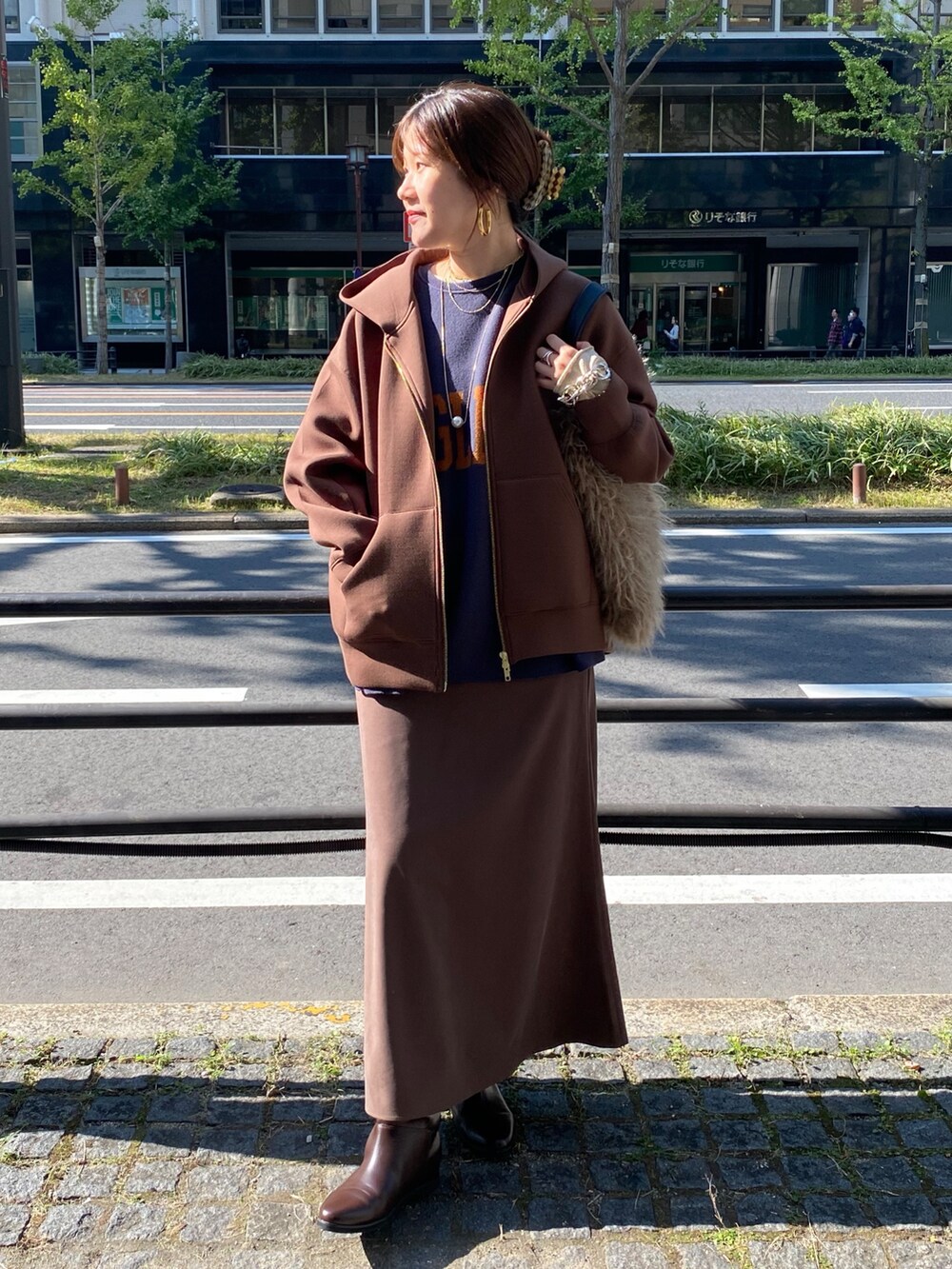 ブラウン系のTシャツ/カットソー、ブラウン系のスカート、ベージュ系のショルダーバッグを着用したレディースの冬コーディネートの5枚目の写真