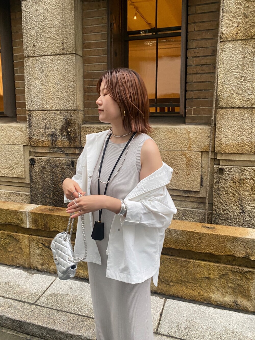 ホワイト系のブルゾン、グレー系のワンピース、シルバー系のショルダーバッグを着用したレディースの春コーディネートの3枚目の写真