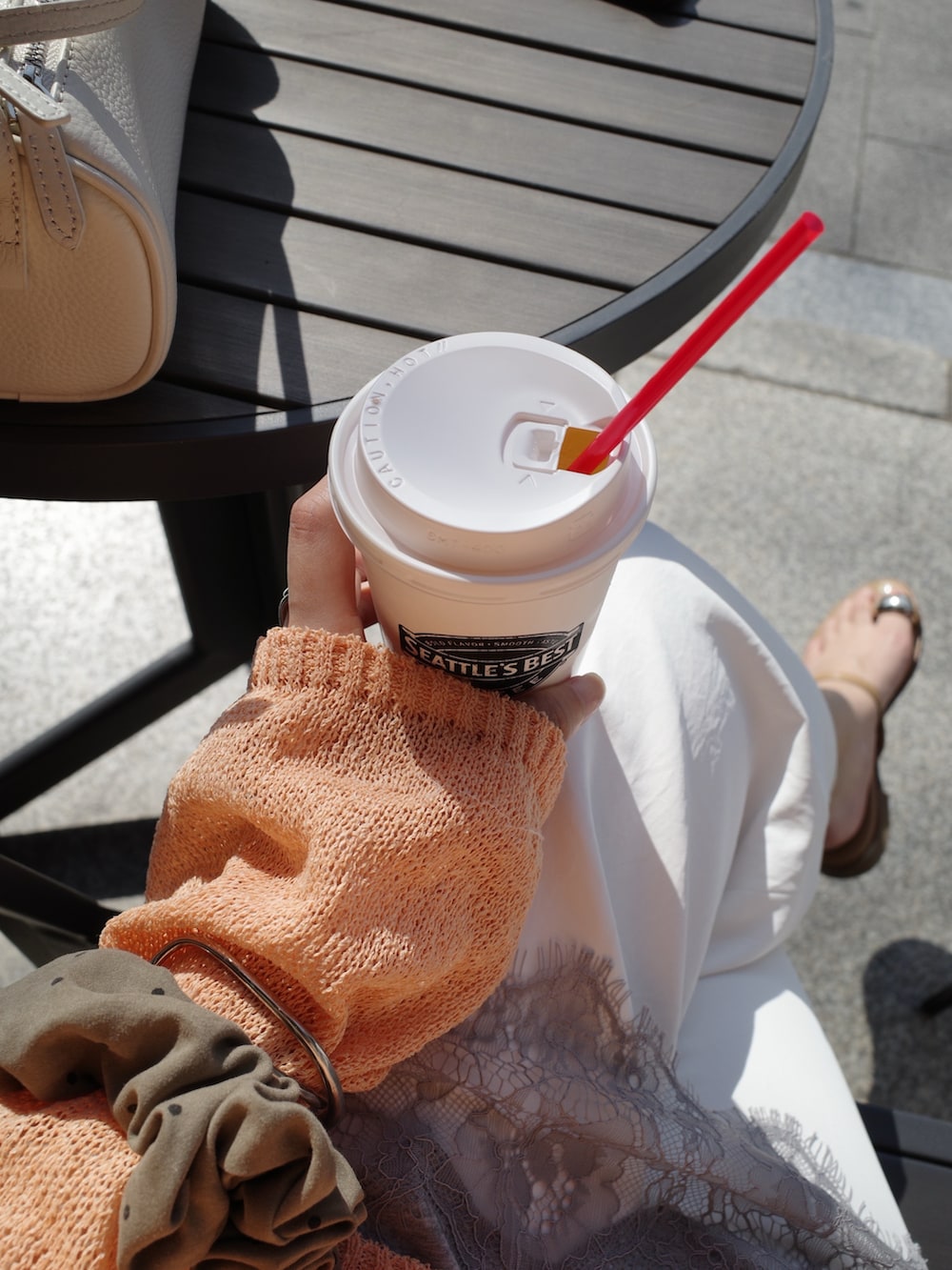 オレンジ系のニット/セーター、グレー系のTシャツ/カットソー、ホワイト系のその他パンツを着用したレディースの春コーディネートの8枚目の写真