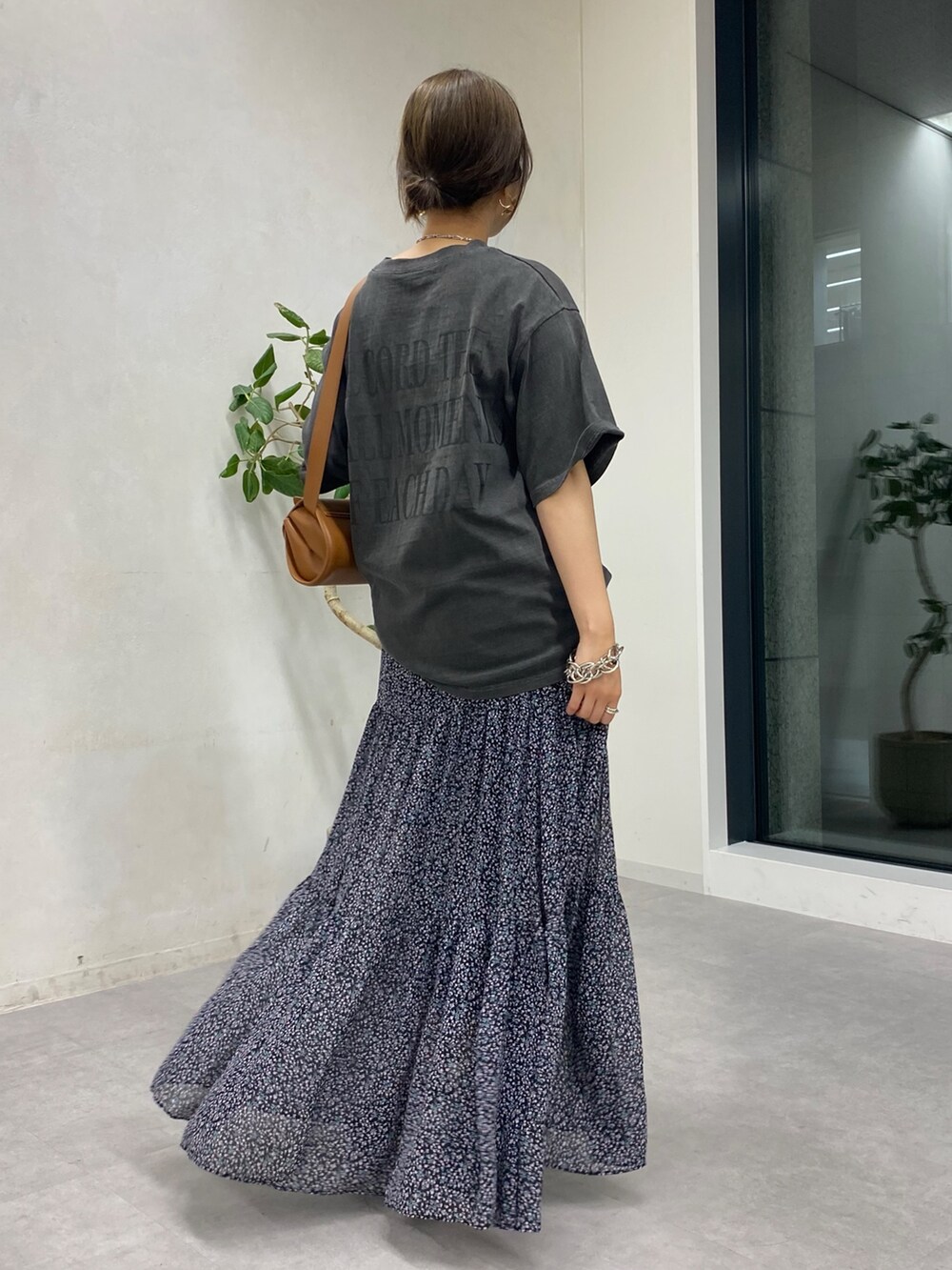 グレー系のTシャツ/カットソー、ピンク系のスカート、ブラウン系のショルダーバッグを着用したレディースの夏コーディネートの4枚目の写真