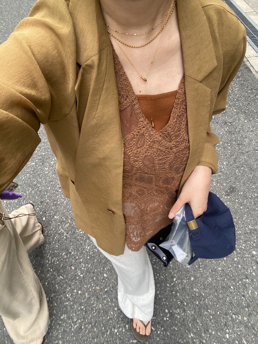 イエロー系のテーラードジャケット、イエロー系のシャツ/ブラウス、ブラウン系のタンクトップを着用したレディースの夏コーディネートの2枚目の写真