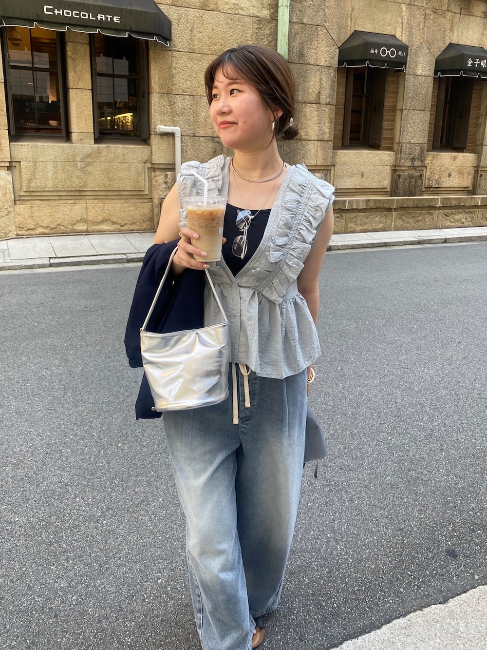 グレー系のシャツ/ブラウス、ブルー系のデニムパンツ、シルバー系のショルダーバッグを着用したレディースの夏コーディネートの6枚目の写真