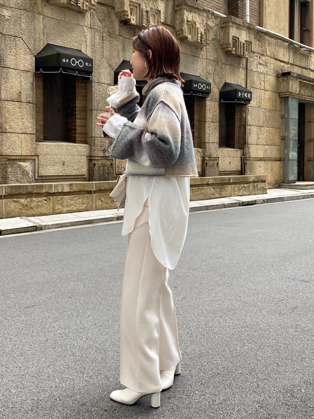 ベージュ系のニット/セーター、ホワイト系のその他パンツ、ホワイト系のトートバッグを着用したレディースの秋コーディネートの4枚目の写真