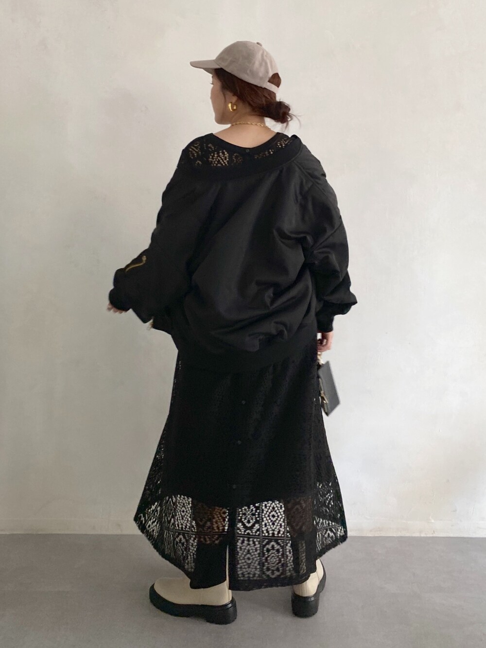 ブラック系のMA-1、ブラック系のワンピース、ホワイト系のブーツを着用したレディースの秋コーディネートの5枚目の写真