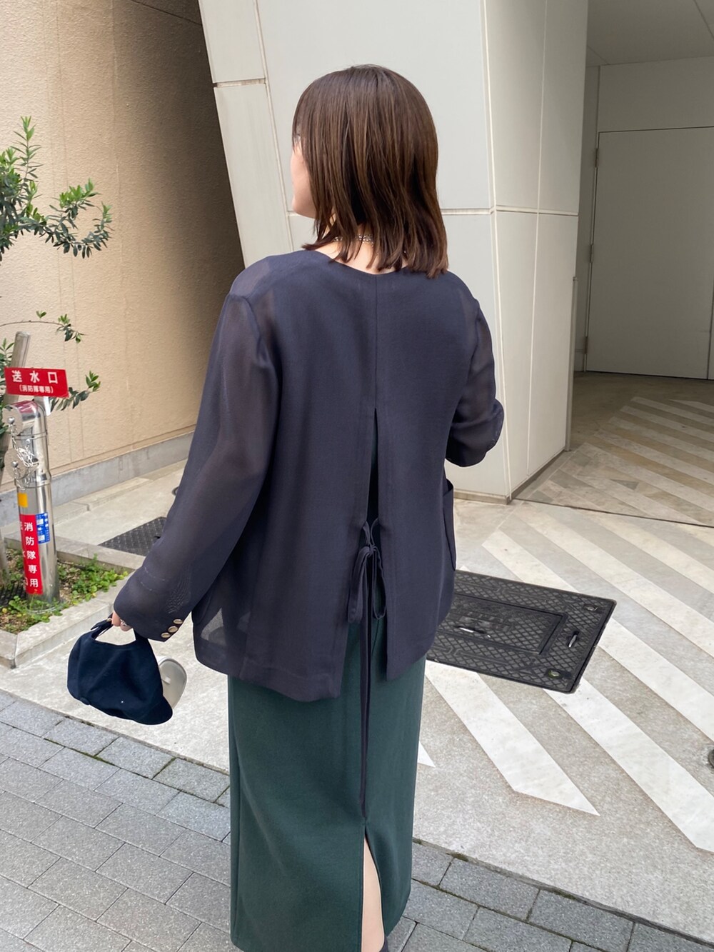 グレー系のテーラードジャケット、グリーン系のワンピースを着用したレディースの春コーディネートの8枚目の写真