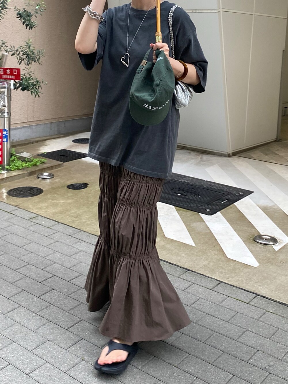 グレー系のTシャツ/カットソー、ブラウン系のスカートを着用したレディースの夏コーディネートの2枚目の写真