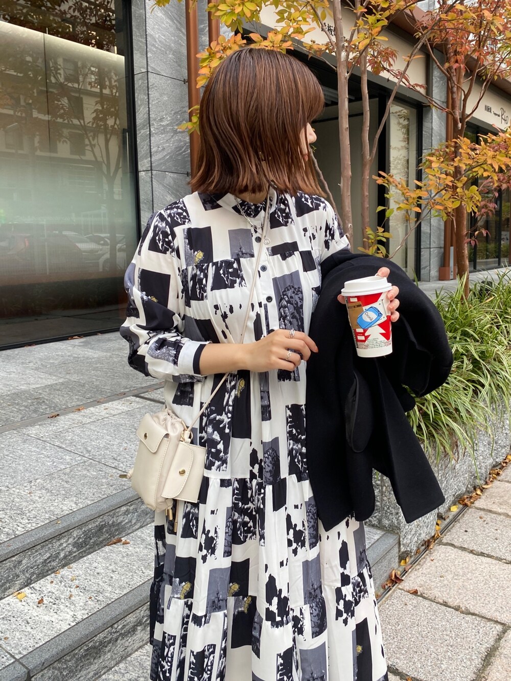 ホワイト系のワンピース、ホワイト系のトートバッグ、ホワイト系のブーツを着用したレディースの秋コーディネートの2枚目の写真