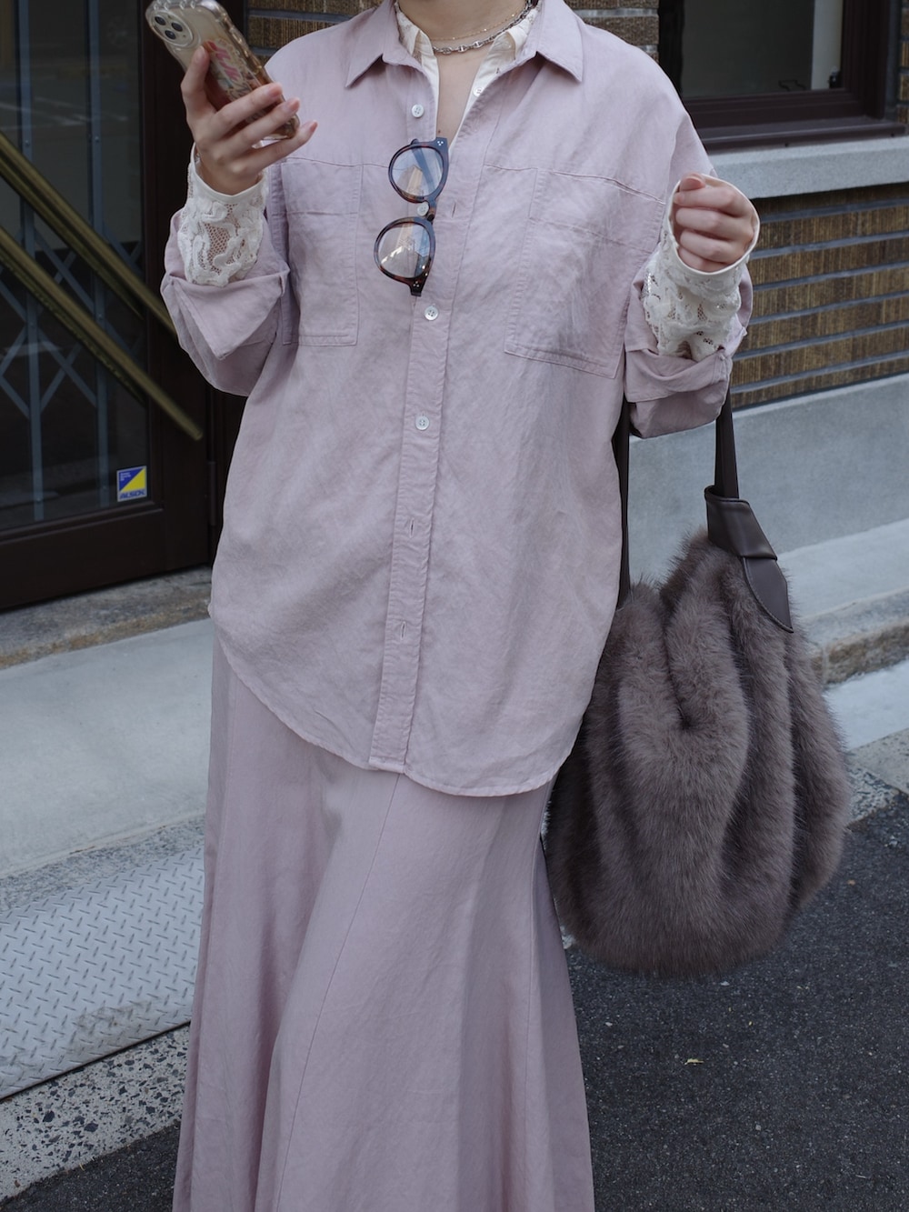 ピンク系のシャツ/ブラウス、ピンク系のスカート、ブラウン系のショルダーバッグを着用したレディースの冬コーディネートの7枚目の写真