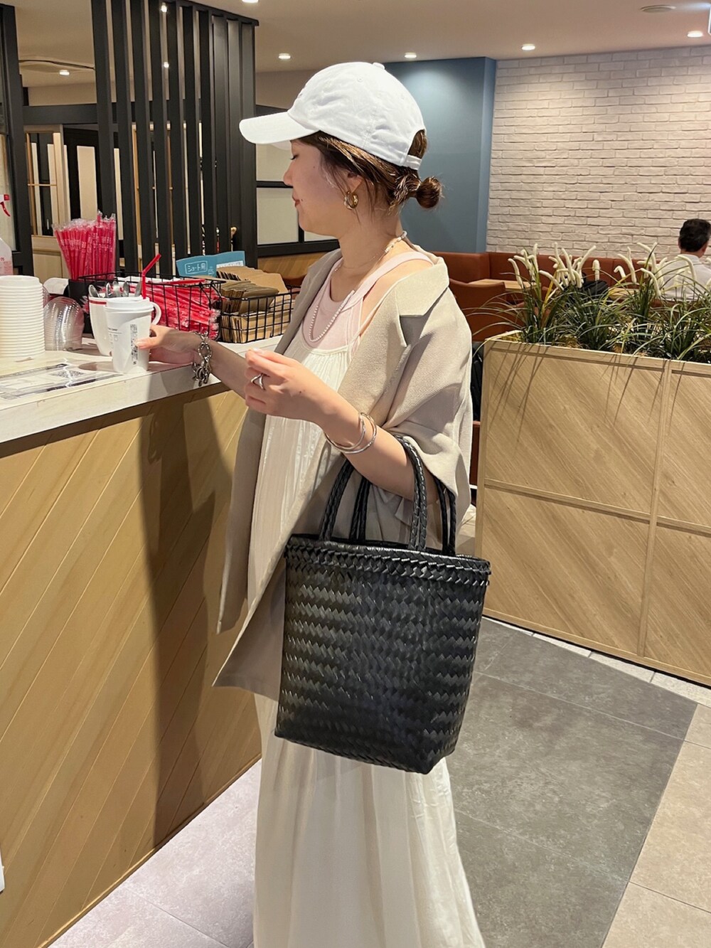 ホワイト系のワンピース、ベージュ系のテーラードジャケット、ホワイト系のキャップを着用したレディースの夏コーディネートの5枚目の写真