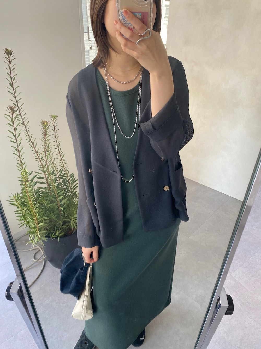 グレー系のテーラードジャケット、グリーン系のワンピースを着用したレディースの春コーディネートの5枚目の写真