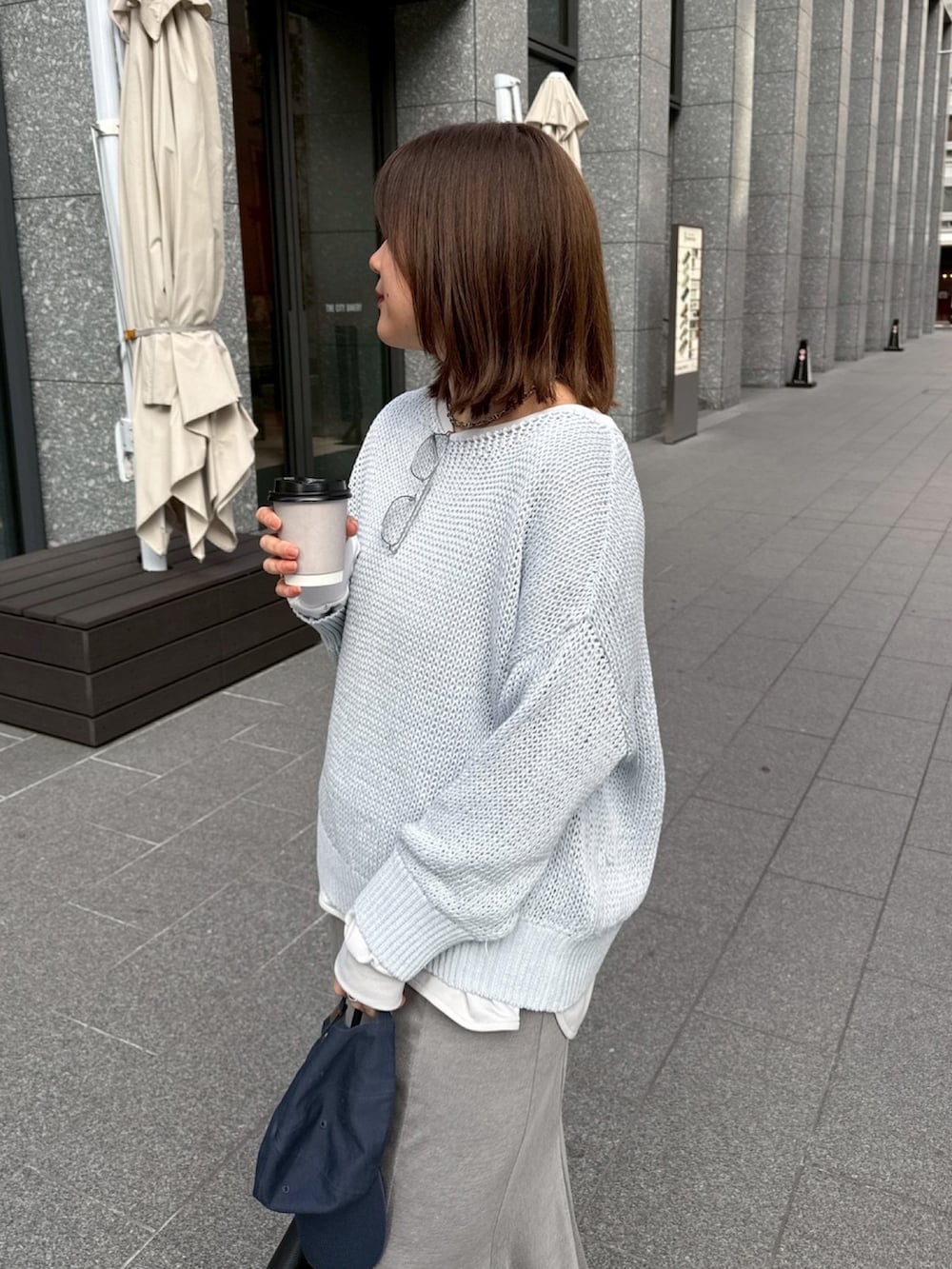 グレー系のTシャツ/カットソー、ブルー系のニット/セーター、グレー系のスカートを着用したレディースの冬コーディネートの7枚目の写真