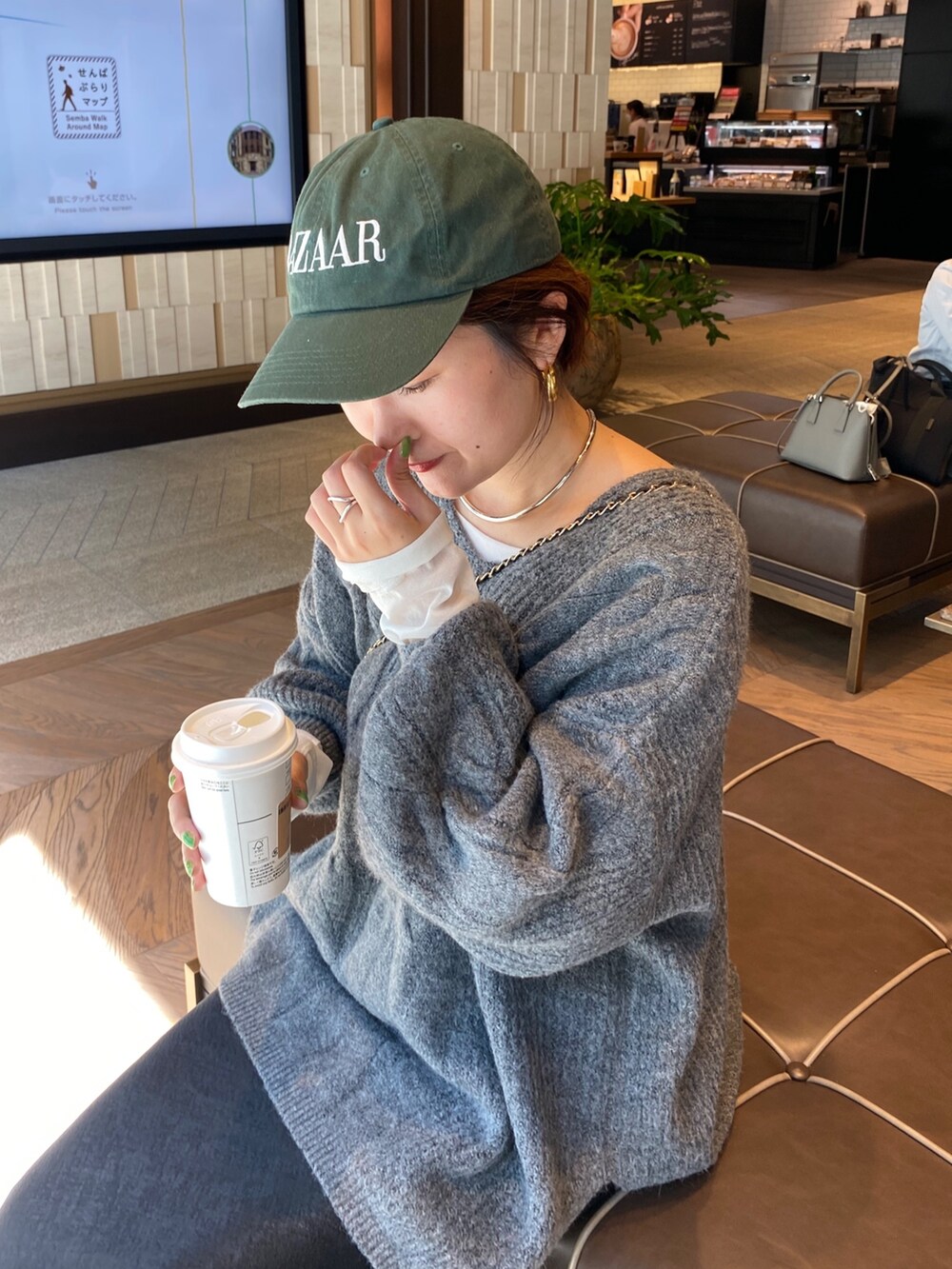 グレー系のニット/セーター、ブラック系のスカートを着用したレディースの秋コーディネートの10枚目の写真